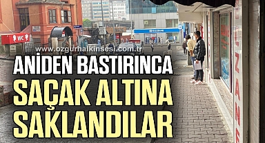 Aniden bastıran yağmurda saçak altına saklandılar