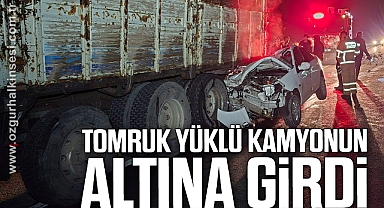 Otomobil, tomruk yüklü kamyonun altına girdi