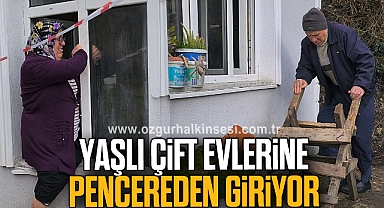 Yaşlı çift, heyelan nedeniyle girişi kapanan evlerine pencereden giriyor