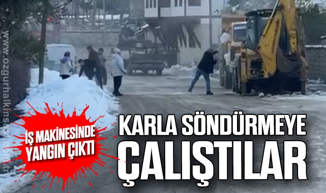 İş makinesinde çıkan yangını karla söndürmeye çalıştılar