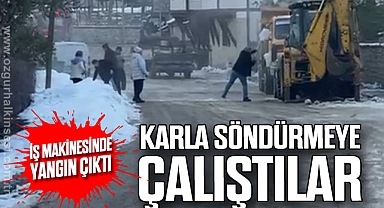İş makinesinde çıkan yangını karla söndürmeye çalıştılar